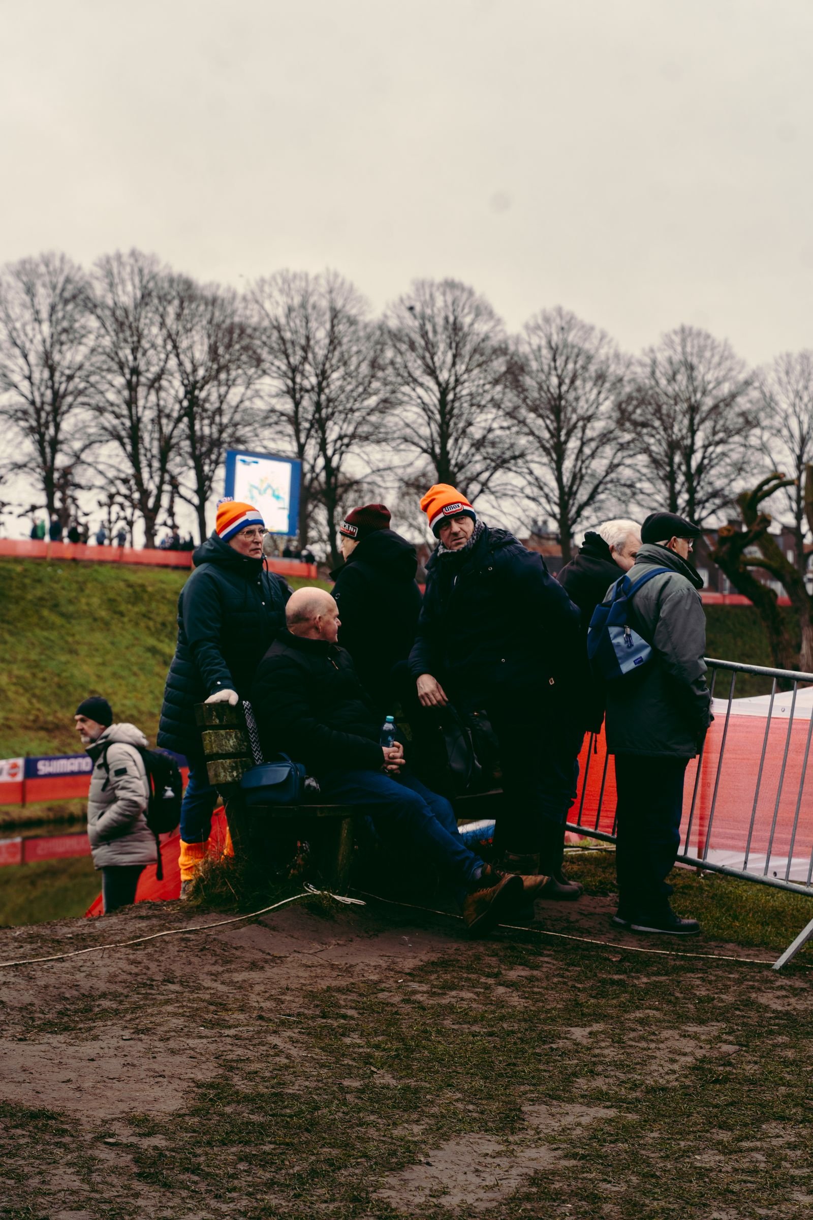 Spectateurs assis sur un banc au bord du parcours