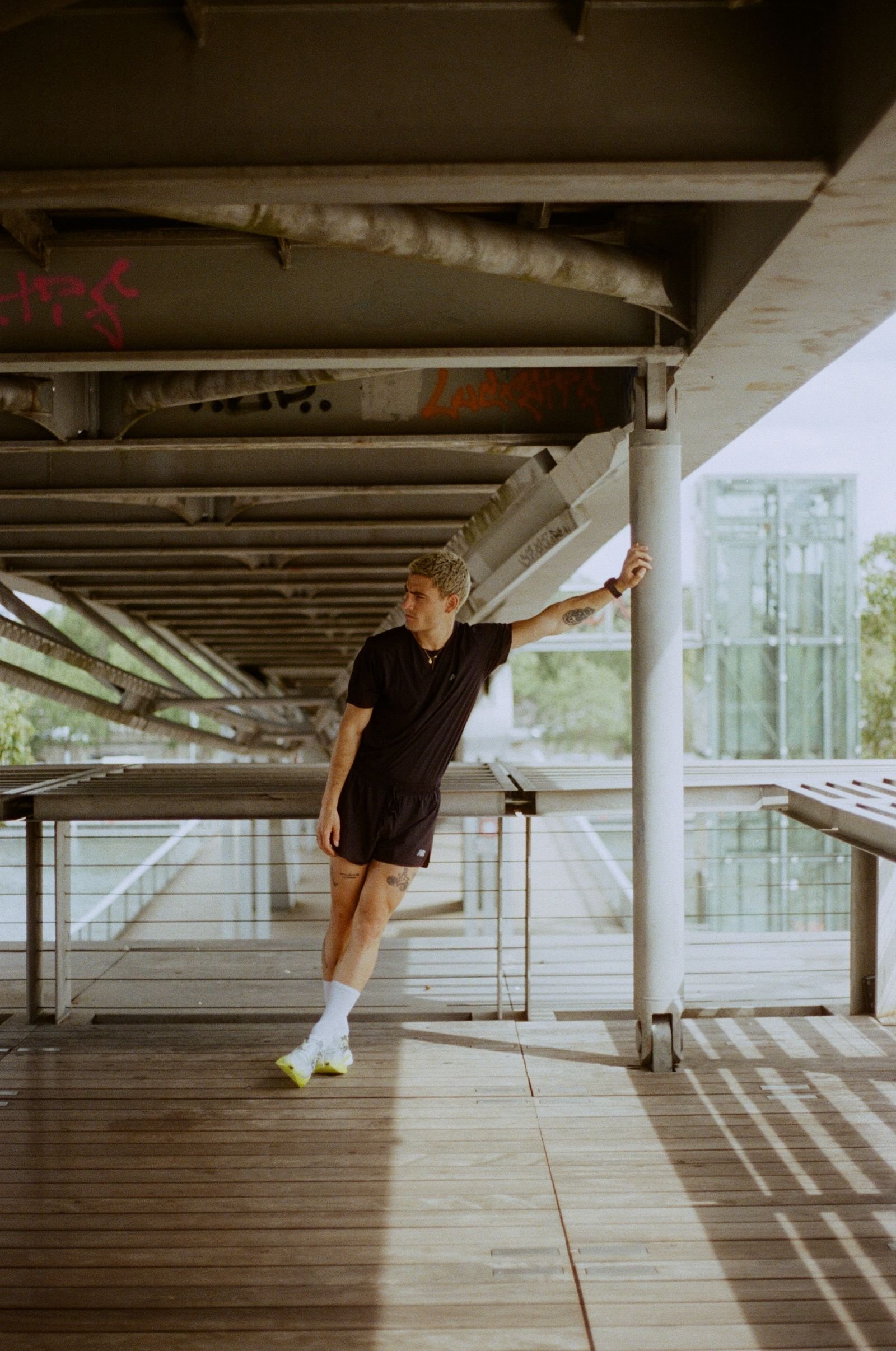 Coureur en appui sur un pilier sous une passerelle