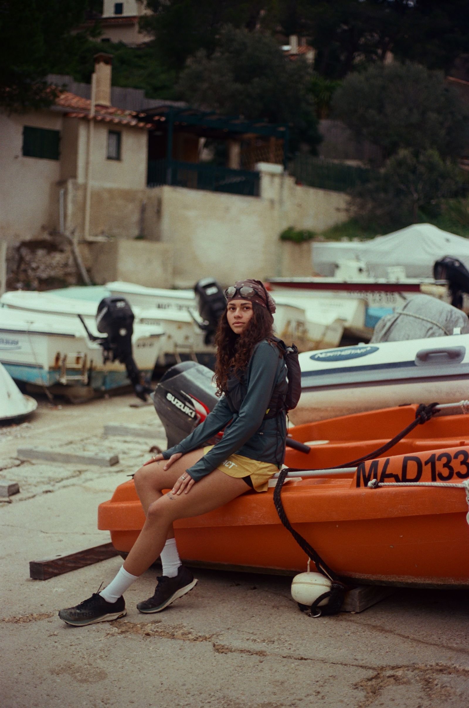 Portrait assise sur un canot orange, port de plaisance