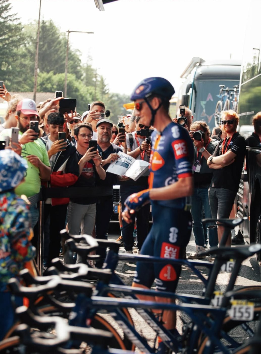 Le coureur passe devant une haie de spectateurs et de photographes