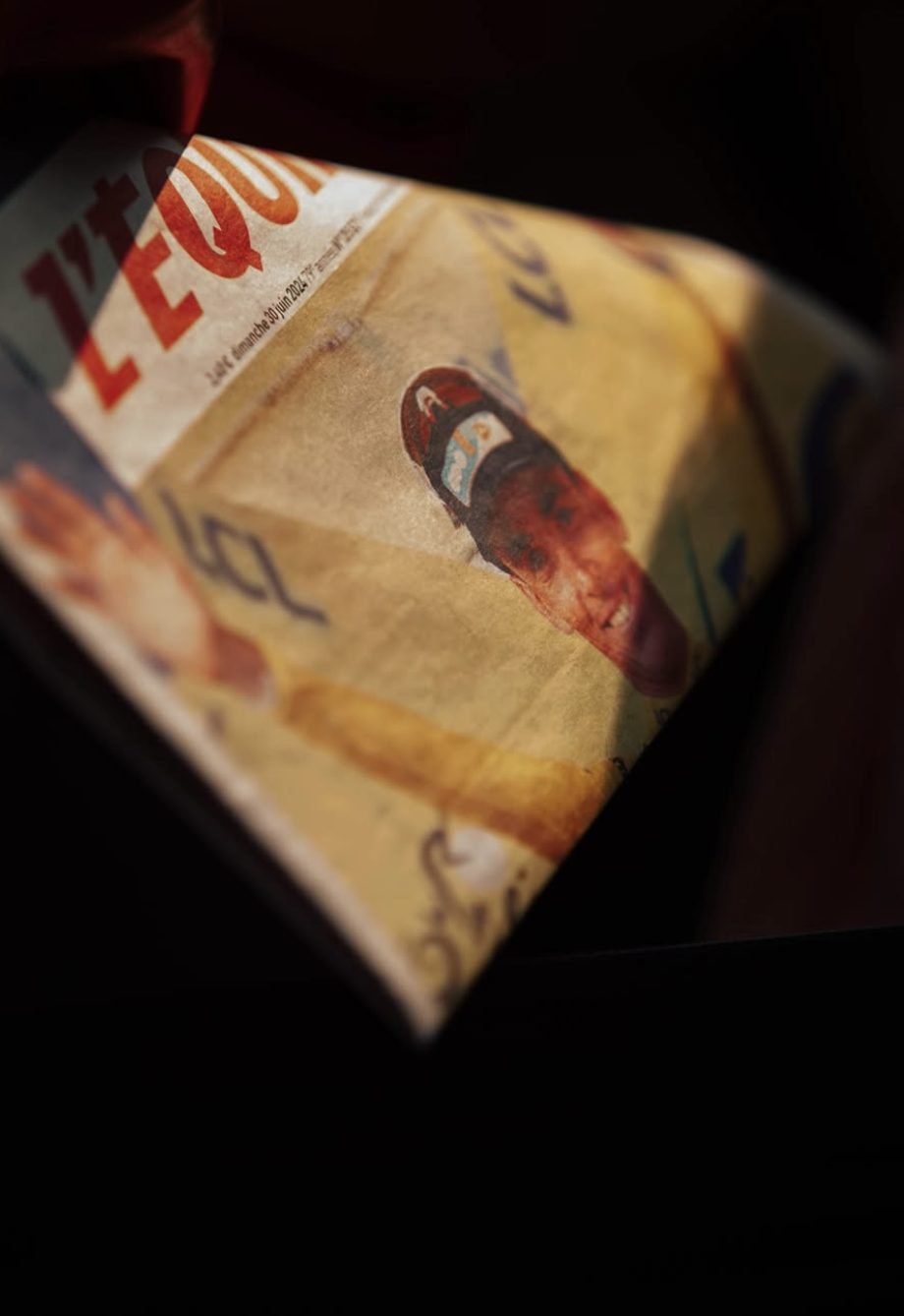 Une du journal L'Équipe posée dans la pénombre